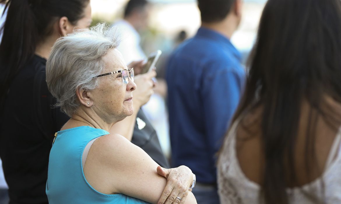 Imagem de uma idosa na fila para pegar o benefício