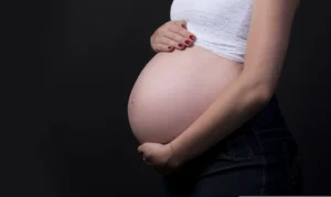 Mulher grávida com a mão sobre a barriga, simbolizando o direito ao salário-maternidade.